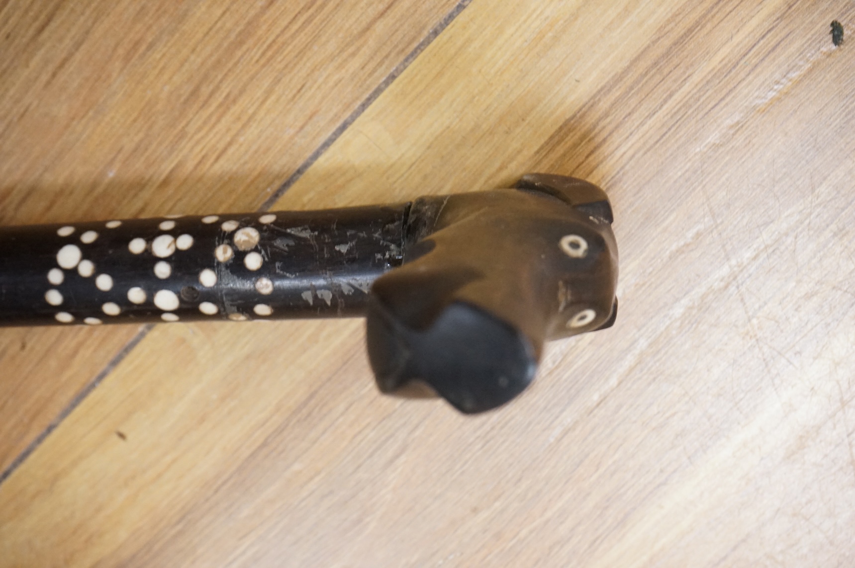 An ebony walking stick with bone inlay, the handle in the form of a dog's head, 88cm in length
